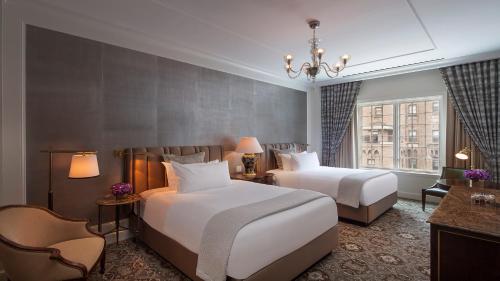 a hotel room with two beds and a chandelier at InterContinental New York Barclay Hotel by IHG in New York