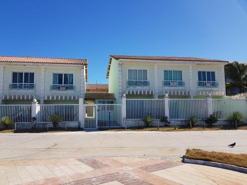 una cerca blanca frente a una casa en Cabo frio Beira mar Praia do Peró, en Cabo Frío