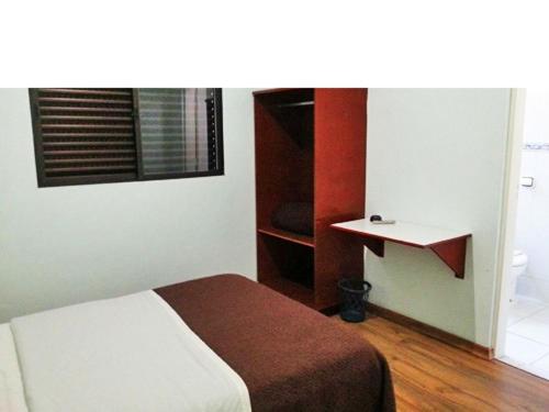 1 dormitorio con cama, estante y ventana en Hotel Gran Valle, en Registro