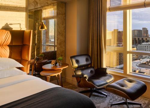 a hotel room with a bed and a chair and a window at Hotel AKA Boston Common in Boston