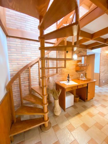 a spiral staircase in a room with a desk at Pousada O Cantinho da Raposa in Monte Verde