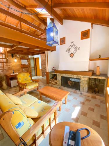 a living room with couches and a fireplace at Pousada O Cantinho da Raposa in Monte Verde