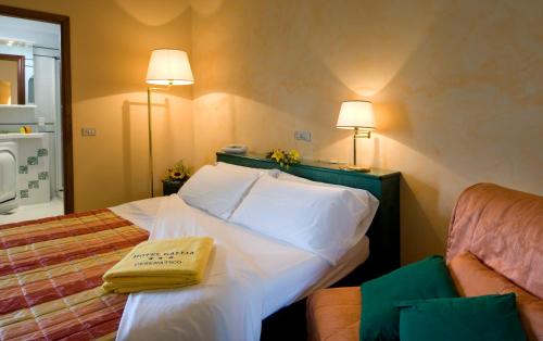 a hotel room with a bed with a book on it at Gallia Club Hotel in Cesenatico
