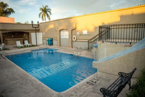 a swimming pool in front of a building at Hotel San Martin in Hermosillo