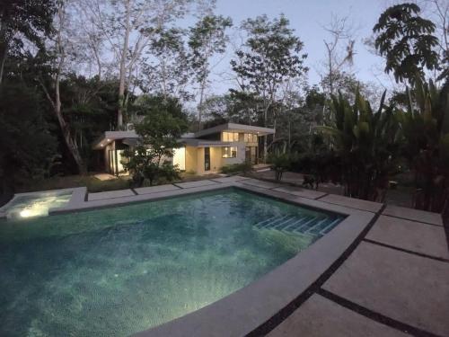 a house with a swimming pool in front of a house at Selva Color - Forest & Beach EcoLodge in Quebrada Ganado