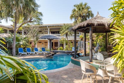 un complejo con piscina, sillas y un edificio en Paramanta Lifestyle Hotel, en Asunción