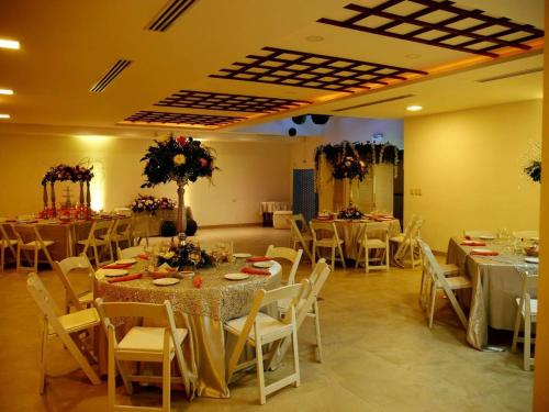 Heroica CaborcaにあるHOTEL POSADA DEL DESIERTOのテーブルと白い椅子が備わる宴会場