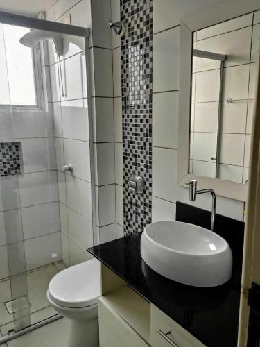 a white bathroom with a sink and a toilet at Apto 2 quartos em Arroio do Silva in Arroio do Silva