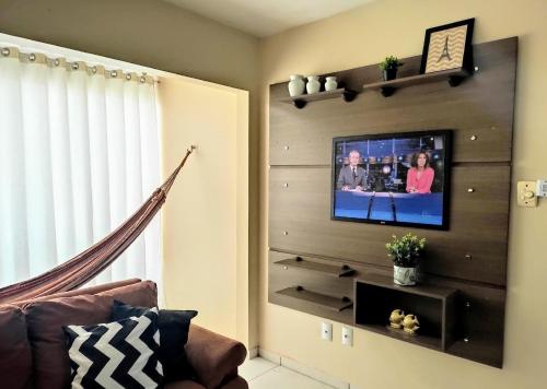 a living room with a flat screen tv on a wall at Apto 2 quartos em Arroio do Silva in Arroio do Silva