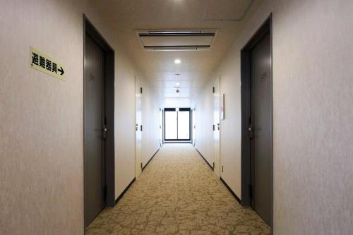 a corridor of an office building with a hallway with doors at Global Resort ONO de LUNE in Hatsukaichi