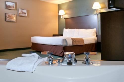 a hotel room with a bed and towels on a counter at AmericInn by Wyndham Green Bay West in Green Bay