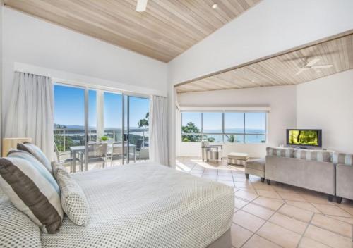 a bedroom with a large bed and a large window at The Lookout Resort Noosa in Noosa Heads