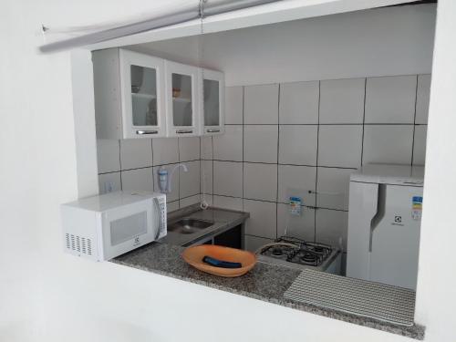una pequeña cocina con fregadero y microondas en Acupe de Brotas, en Salvador