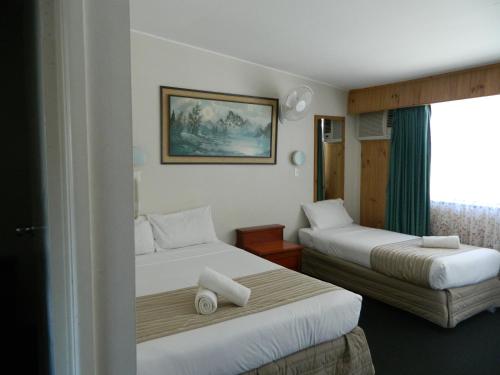 Кровать или кровати в номере Coachman Motel