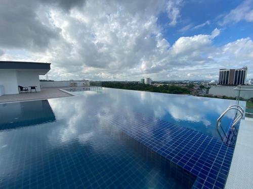 a infinity pool on the roof of a building at Cozy Studio at Kozi Square in Kuching