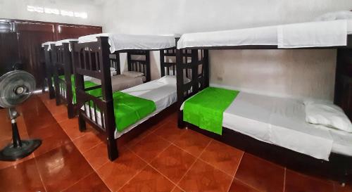 two bunk beds in a room with a fan at Hotel Sol del Desierto in Villavieja