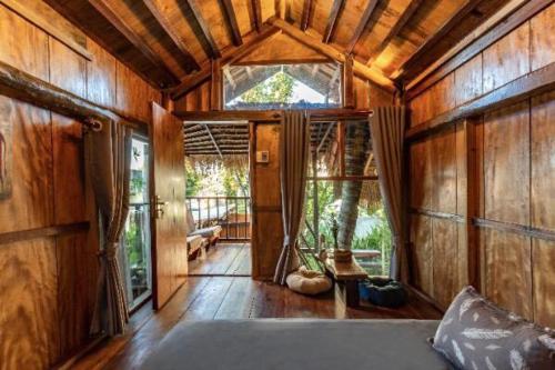 a bedroom with a bed in a room with wooden walls at Cat Homestay in Hue