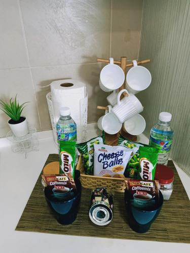 a counter with a basket of snacks and water at D'Gunduls Homestay STUDIO by DGH I-CITY in Shah Alam