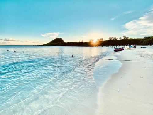 a beach with a group of people in the water at Kenting Sunhow Inn in Kenting