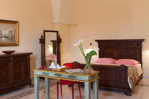 a bedroom with a bed and a table with a vase on it at Villa Urso bed&breakfast in Monteroni di Lecce