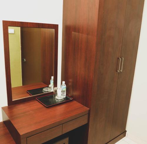 a bathroom with a wooden vanity with a mirror at Bayu View Hotel Klang in Klang