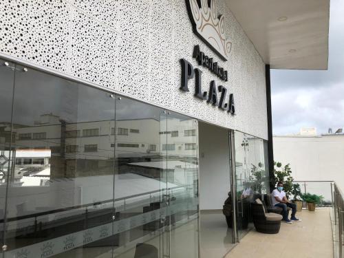 a man sitting on a couch in front of a building at Apartahotel Plaza in San Andrés