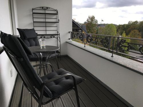un balcón con 2 sillas y una mesa. en Großzügiges Appartement -ruhig und doch zentral, en Odenthal