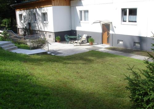 een huis met een patio en een grasveld bij Ferienwohnung am Spitzberg in Suhl