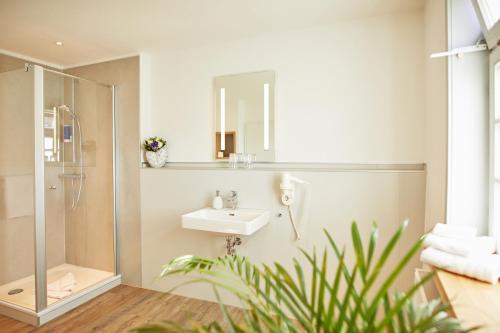 uma casa de banho com um lavatório e um chuveiro em Hotel Landgraf em Schwalmstadt