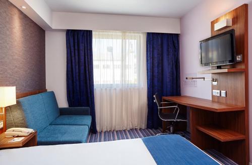 a hotel room with a bed and a tv at Holiday Inn Express Lisbon Alfragide by IHG in Carnaxide