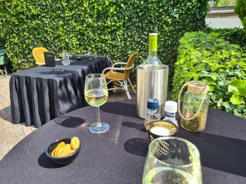 a table with wine glasses and a bottle of wine at Amsterdam Hotel Uithoorn in Uithoorn