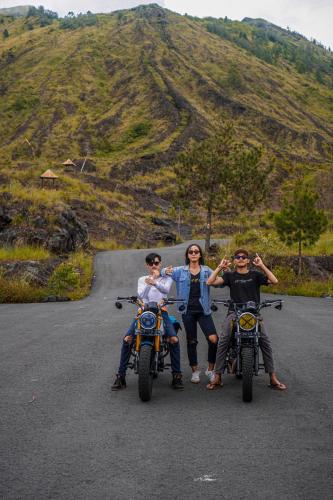 a group of three people on motorcycles on a road at Batur Volcano Guesthouse in Kintamani