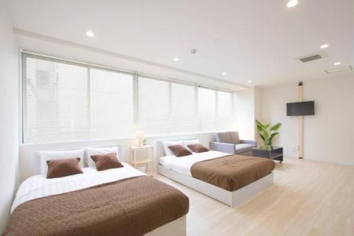 - une chambre avec deux lits et un canapé dans l'établissement Cozy and Convenient Royal heights, à Sapporo