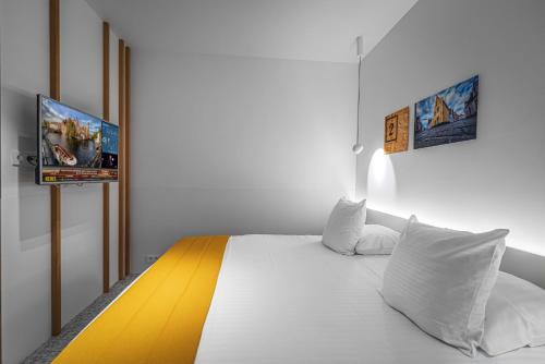 a bedroom with a bed with a tv on the wall at Hotel Bourgoensch Hof in Bruges