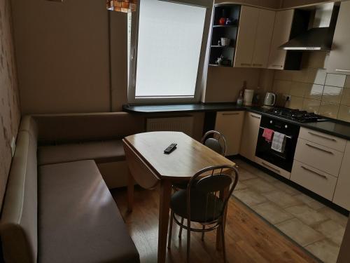 a small kitchen with a small table and a window at Sunny apartment Kėdainiai in Kėdainiai