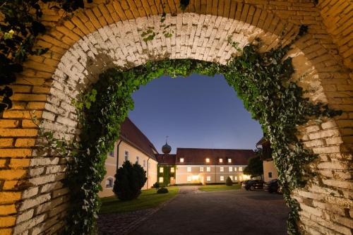 an arch of a brick wall covered in ivy at Klosterhof St. Salvator in Bad Griesbach