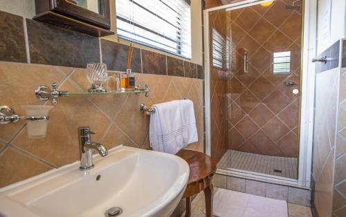 a bathroom with a sink and a shower at At Heritage House in St Lucia