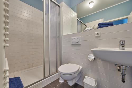 ein weißes Bad mit einem WC und einem Waschbecken in der Unterkunft Laguna Seeappartements in Neukieritzsch