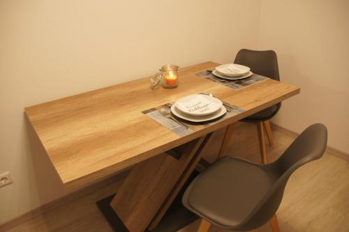 a wooden table with two chairs and a candle on it at Ferienwohnung Jurastein in Burglengenfeld