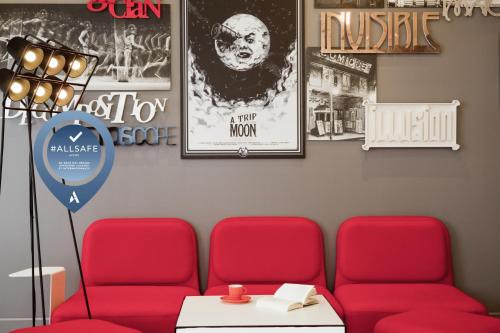 a waiting room with two red chairs and posters at ibis Styles Paris Mairie de Montreuil in Montreuil