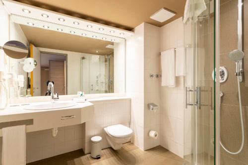 ヒルデスハイムにあるパークホテル ベルクヘールツヘンのバスルーム(トイレ、洗面台、シャワー付)