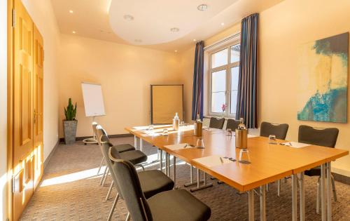 a conference room with a long table and chairs at Parkhotel Berghölzchen in Hildesheim