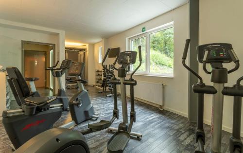 a gym with several tread machines in a room at Parkhotel Berghölzchen in Hildesheim