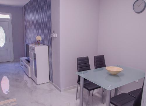 a dining room with a table and two chairs at Oros House Apartmanház in Orosháza