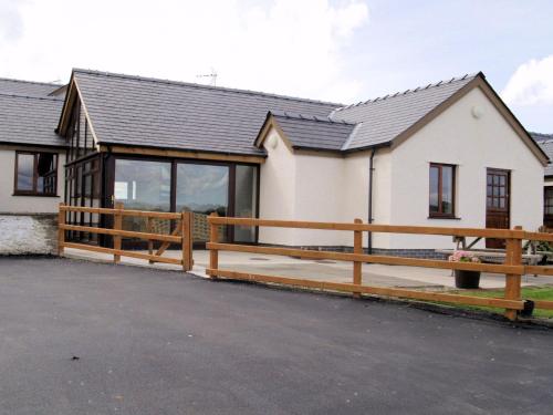 a house with a wooden fence in front of it at The Dairy in Aberystwyth