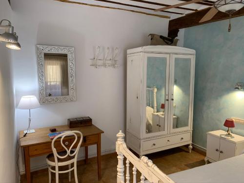 une pièce avec une armoire blanche et un bureau dans l'établissement Casa rural Cora de Tudmir, à Moratalla