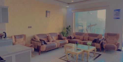 a living room with couches and a coffee table at شاليهات لودج in Al Humaizah