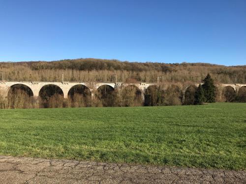 a bridge over a field with a green field at Vakantiehuis - Rue du Château Deux in Voeren