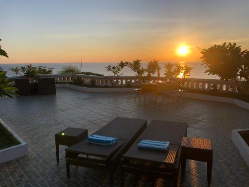 a sunset over a patio with tables and chairs at Argonauta Boracay Apartment Suites and Villas in Boracay