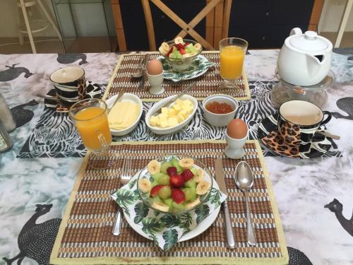 un tavolo con un piatto di cibo e un cesto di frutta di Tropical Paradise a Southbroom